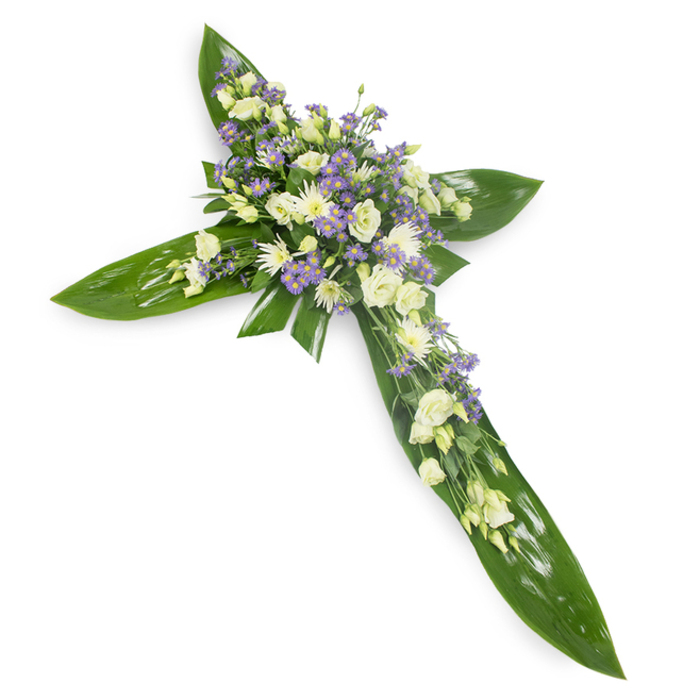 This floral cross, photographed from a modest overhead viewpoint against a plain white surface, marries architectural foliage with tender, subdued blooms to create a composed sympathy piece. The base is a lush lattice of large tropical leaves - think Ti or similar glossy greens - their broad blades layered to carve the vertical and horizontal lines of the cross with an almost sculptural clarity. At the core and along the main axis, clusters of soft white and creamy lisianthus gather in generous, ruffled masses; each bloom unfurls with delicate layering that reads as both fragile and resilient. Interspersed among these are compact white spray chrysanthemums or miniature rose-like buds, offering small, luminous points that contrast pleasingly with the leaf sheen. Light lavender sprays of tiny aster-like flowers, possibly limonium, are dotted throughout, their starry forms adding an airy, contemplative purple whisper that complements the dominantly pale palette. Fine green filler foliage is woven through the composition, giving the arrangement a sense of depth and a gently wild, natural touch. The tactile contrasts - smooth, glossy leaves against velvety petals - are clear even without colour: cool greens, soft whites, and the faintest hint of lilac. The image evokes reverence and solace, suitable for funerals, memorial services, or church tributes in Merton neighbourhoods such as Colliers Wood or South Wimbledon, where families often choose a cross to signify faith, hope, and enduring remembrance.