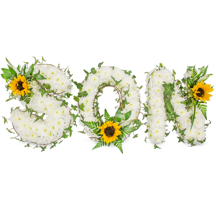 A three-letter floral memorial spells SON in strong, capital forms, each letter densely covered with pristine white chrysanthemums to create a textured, cloud-like surface that reads soft and luminous beneath measured studio lighting. The chrysanthemums are closely set so the eye perceives a continuous field of white, punctuated by winding strands of dark green ivy threaded through and around the letters; the ivy's glossy, five-lobed leaves provide sculptural contrast and a sense of evergreen continuity. Interspersed among the white are pockets of lighter green fern fronds and assorted pointed leaves that add depth, shadow, and natural line to the composition-particularly within the hollow of the O where the foliage fans outward. Three large sunflowers act as focal anchors: a sunflower with a deep brown centre is placed at the upper-left curve of the S, another rests at the lower centre of the O surrounded by fern fronds, and the third bright bloom adorns the upper-right corner of the N. Their golden-yellow petals radiate warmth against the neutral white, introducing a note of tenderness and remembrance. Shot against a clean white backdrop, the image emphasizes textural contrasts-the chrysanthemums' soft petals, the ivy's sheen, the sunflower's coarse disc-and conveys the careful craftsmanship of a funeral florist. This elegant, bespoke tribute serves as a poignant memorial for a beloved son, marrying traditional symbols of peace and purity with the uplifting presence of sunflowers to suggest light amid sorrow.