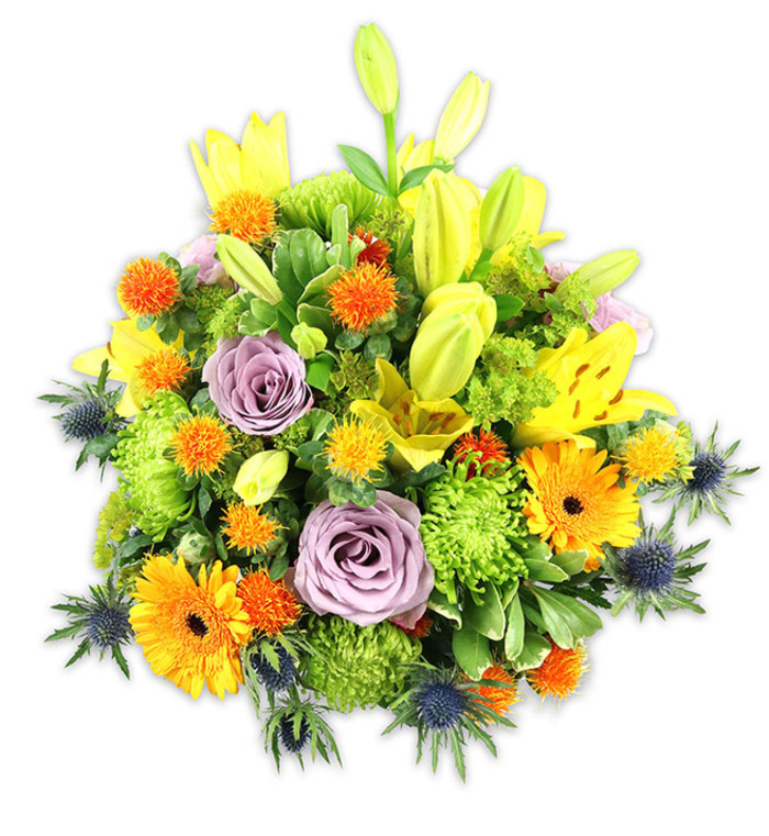 A richly layered, mounded bouquet sits against a white backdrop, each element chosen for contrast, scent and seasonal cheer. The ensemble is anchored by luminous yellow Asiatic lilies-some opened wide with speckled throats and filamented stamens, others remaining slender chartreuse buds that add vertical movement-while soft lavender-purple roses nestle low, their velvety petals spiralling inward like a gentle breath. Bold orange Gerbera daisies scatter warm, flat discs of colour across the surface, their darker centres lending depth, and bright lime-green button chrysanthemums fill gaps with a textured, almost cushion-like volume. Dotted through the mass are small spherical orange and sunny-yellow accent blooms, lending playful punctuation and a slightly prickly textural note. Dramatic blue-grey Eryngium thistles appear along the sides and lower planes, their spiky bracts and steelier hues providing a modern, architectural counterpoint to the softer blossoms. A mix of glossy and matte greens-broad lily leaves, smaller oval foliage and wispy fillers-frames the palette and gives the bouquet fullness and movement. The overall impression is warm, celebratory and comforting: a versatile arrangement suitable for birthdays, congratulations, or as a thoughtful remembrance. As a florist working in Merton, I picture this arrangement brightening a hallway table near Wimbledon High Street or being carefully wrapped for same-day local delivery to Raynes Park; it is an expression of seasonal vibrancy crafted with neighbourhood care by Flower Delivery Merton.
